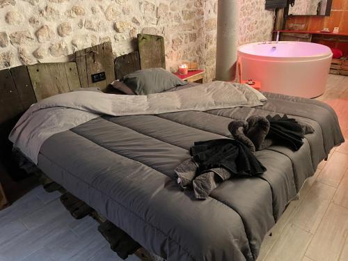 a large bed in a room with clothes on it at mauho breulè in Satillieu