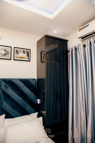 a bedroom with a black cabinet and a bed at Cozy Akoka Studio Near Unilag in Lagos