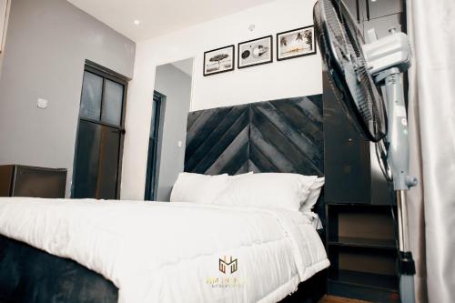 a bedroom with a large bed with a wooden headboard at Cozy Akoka Studio Near Unilag in Lagos
