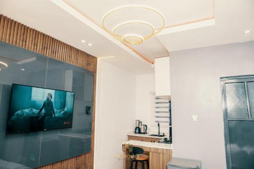 a living room with a flat screen tv on a wall at Cozy Akoka Studio Near Unilag in Lagos