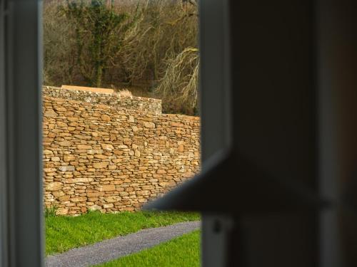 a view of a stone wall from a window at Fowlescombe Farm in Ugborough