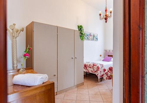a room with a bedroom with a bed and a cabinet at Hostly - Il Gelsomino di San Prospero in Cascina