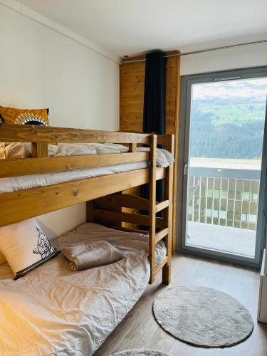 - une chambre avec 2 lits superposés et une grande fenêtre dans l'établissement appartement petite ours flaine 2chambres avec wifi, à Flaine