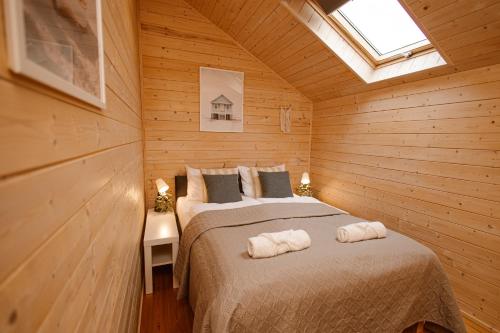 a bedroom with two beds in a wooden room at Rafa Międzywodzie in Międzywodzie