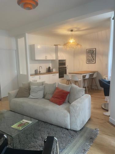 un salon avec un canapé blanc et une cuisine dans l'établissement Appartement rénové Bourse, à Bordeaux