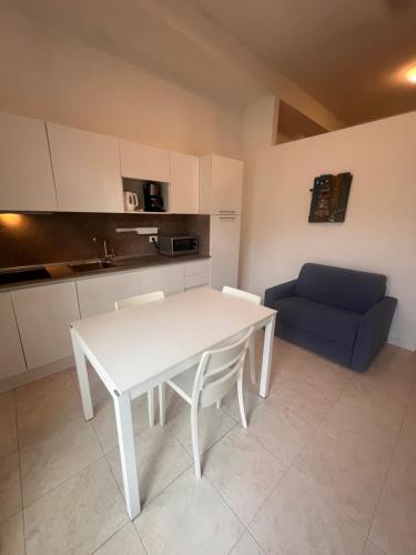 a kitchen with a white table and a blue couch at Dune Prestige & Chalets in Bibione