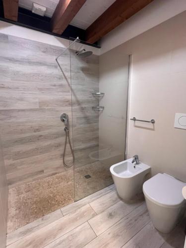 a bathroom with a shower with a toilet and a sink at Dune Prestige & Chalets in Bibione