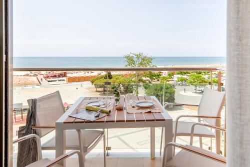 a table and chairs on a balcony with a view of the ocean at La Francesa Algarve in Monte Gordo