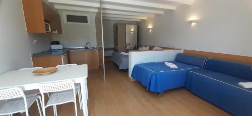 a living room with a blue couch and a kitchen at Sintra Sol - Apartamentos Turisticos in Sintra