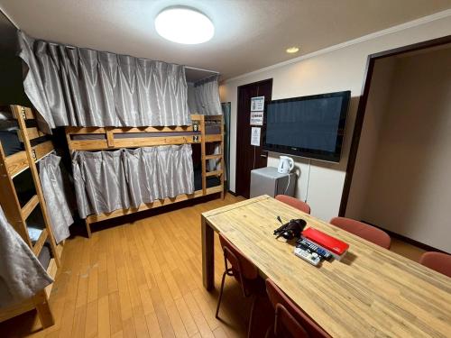 a room with two bunk beds and a table and a room with a tv at Tokyo House INN in Tokyo