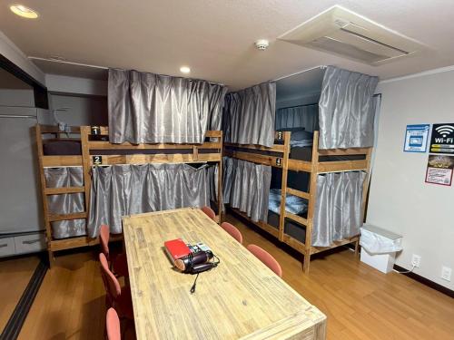 a room with a table and two bunk beds at Tokyo House INN in Tokyo