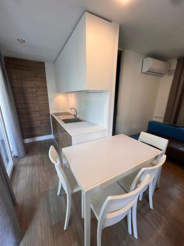 a small kitchen with a white table and chairs at Dune Prestige & Chalets in Bibione
