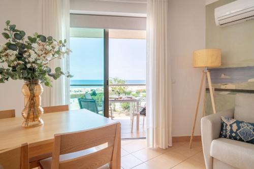 a living room with a table with a vase of flowers at La Francesa Algarve in Monte Gordo