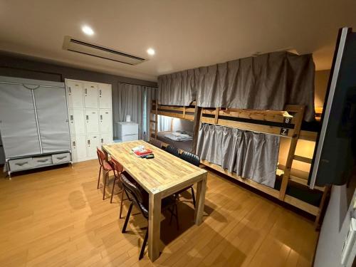 a room with a table and a bunk bed at Tokyo House INN in Tokyo