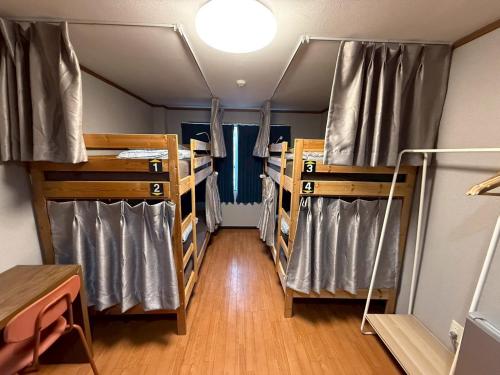 a room with several bunk beds and a table at Tokyo House INN in Tokyo
