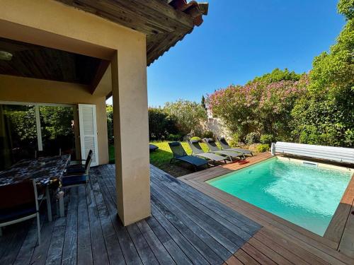 une terrasse avec une piscine, une table et des chaises dans l'établissement Villa Marina Rossa - plage à pied, à Lecci