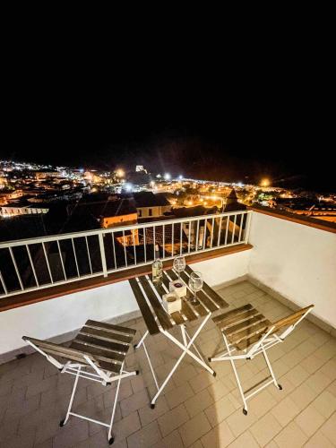 a balcony with two chairs and a table with a view at Roof top Terrace house in Scalea