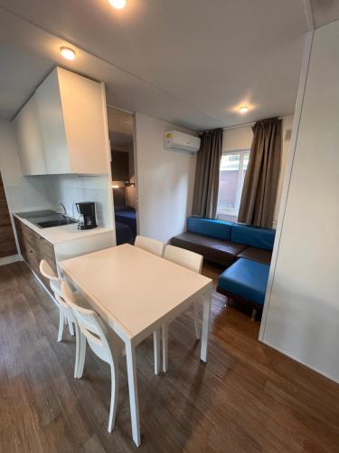 a room with a table and a kitchen and a couch at Dune Prestige & Chalets in Bibione