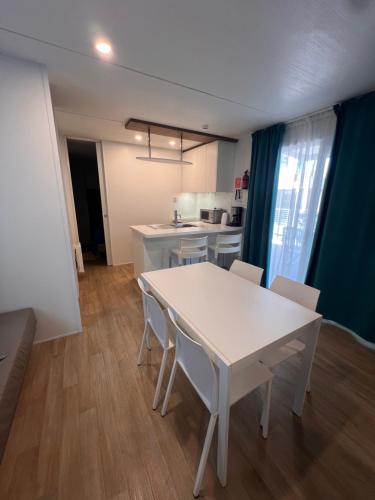 a kitchen with a white table and chairs in a room at Dune Prestige & Chalets in Bibione