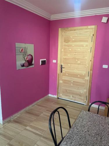 a room with purple walls and a wooden door at cosy Furnished appartment in Ez Zahra