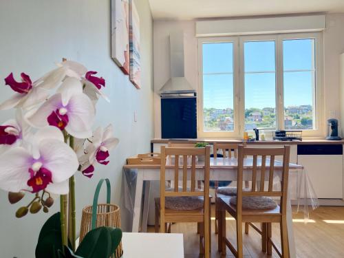 una cucina e una sala da pranzo con tavolo e sedie di L'éclat à trois pas de la mer a Ault
