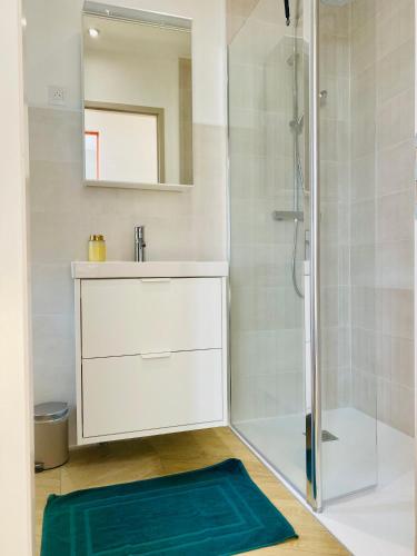 une salle de bain avec une douche, un lavabo et un miroir dans l'établissement L'éclat à trois pas de la mer, à Ault