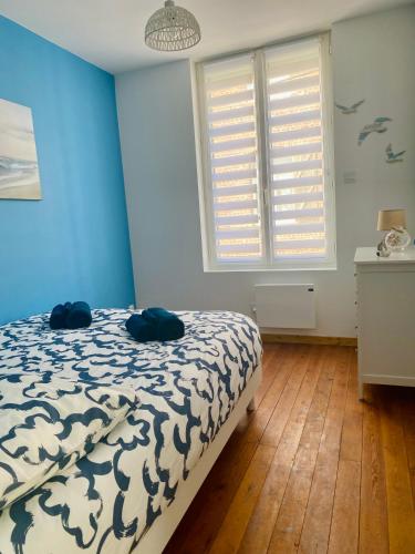 une chambre avec un lit aux murs bleus et une fenêtre dans l'établissement L'éclat à trois pas de la mer, à Ault