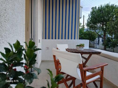 a table and chairs on a balcony with a building at Studio Sykea SgS in Xylokastron