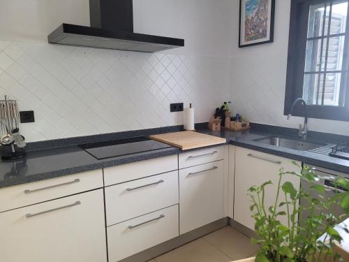 a kitchen with white cabinets and a sink at Villa Vista with heated pool & Jacuzzi in Playa Blanca