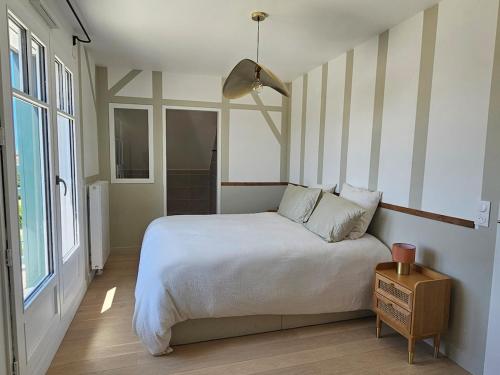 une chambre avec un grand lit blanc et une fenêtre dans l'établissement Beautiful family home, 4 bedrooms, 3 bathrooms, quiet, lovely place, à Deauville