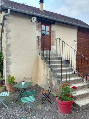 a house with a table and chairs in front of it at Gîte au coeur de la forêt in Saint-Parize-le-Châtel