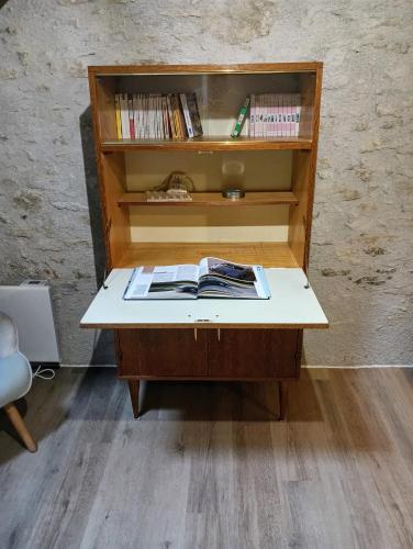 a desk with a book shelf with books on it at Gîte au coeur de la forêt in Saint-Parize-le-Châtel