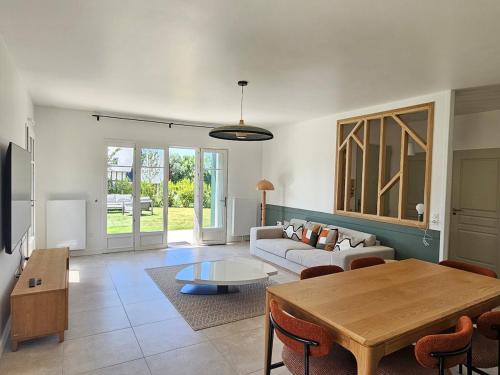 un salon avec une table et un canapé dans l'établissement Beautiful family home, 4 bedrooms, 3 bathrooms, quiet, lovely place, à Deauville