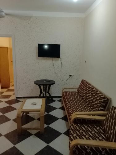 a room with a couch and a tv on a wall at برج القط للشقق الفندقيه المفروشة in Marsa Matruh