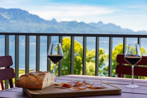 a table with two glasses of wine and a plate of bread at Les Terrasses de Lavaux-2 Appartement de Luxe avec Vue Panoramique et Piscine" in Chexbres