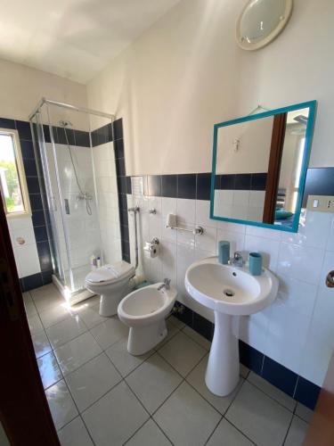 a bathroom with two toilets and a sink and a mirror at La Bussola in Porto Palo
