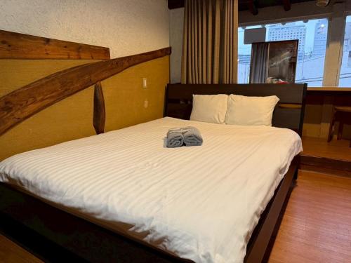 a bedroom with a bed with a towel on it at Tokyo House INN in Tokyo