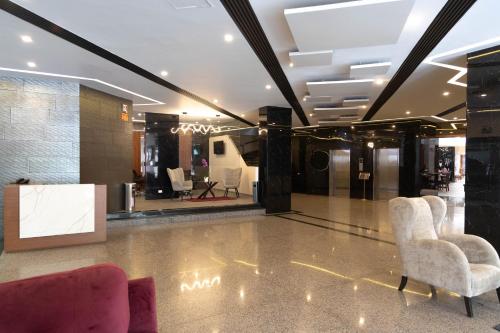 a lobby with two chairs and a mirror at Hotel Abastos Plaza in Mexico City