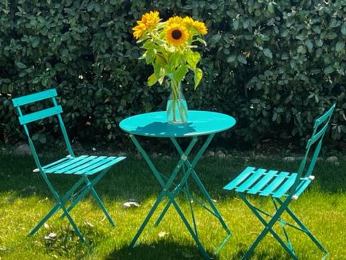 two chairs and a table with a vase of sunflowers on it at Domaine Les feuilles de Chêne in Carpentras