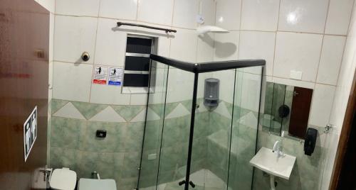 a bathroom with a glass shower with a toilet and a sink at Hostel Anprado 2 kit café incluso, Próx-Aeroporto de Guarulhos in Guarulhos