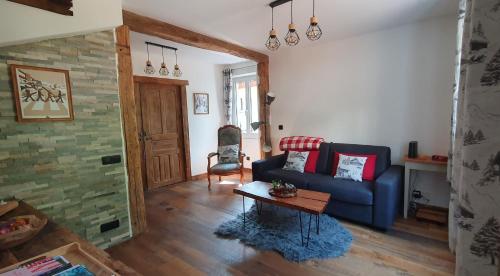 a living room with a blue couch and a table at le home du Morel et son jacuzzi in Bellecombe