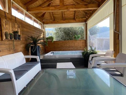a screened in porch with a swimming pool and a table and chairs at גרין פארק - קוטג' מהמם עם בריכה וג'קוזי בעין קנייא in Ein Kinya