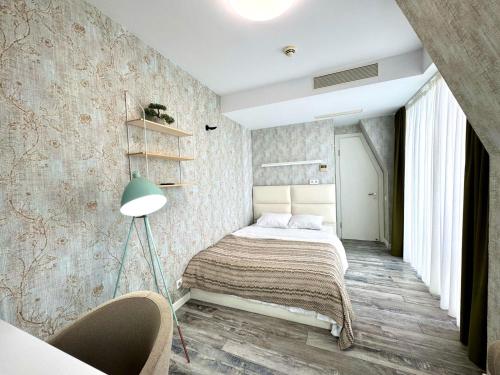 a bedroom with a bed and a lamp at My Sunshine Apartments in Batumi in Batumi