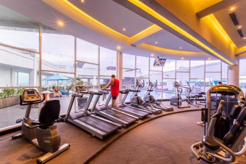 a man in a gym with cardio equipment at Grand Jatra Hotel Balikpapan in Balikpapan