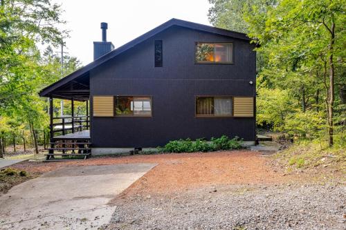 a black house in the middle of the forest at Mizunara Terrace Karuizawa in Karuizawa