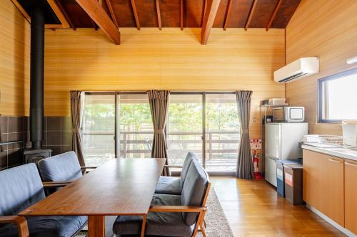 軽井沢町にあるMizunara Terrace Karuizawaの部屋にテーブルと椅子のあるキッチン