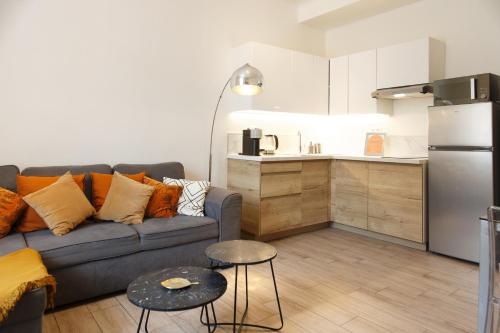 un salon avec un canapé et une cuisine dans l'établissement Luciana Cannes avec parking - proximité centre croisette -gare -plage, à Cannes