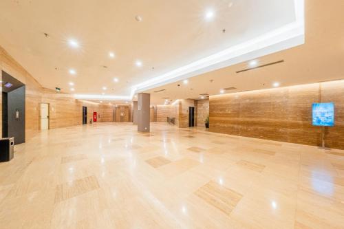 an empty lobby with wooden floors and a large wall at Grand Jatra Hotel Balikpapan in Balikpapan