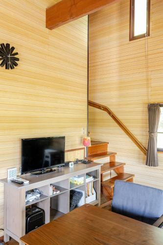 a living room with a flat screen tv and a table at Mizunara Terrace Karuizawa in Karuizawa