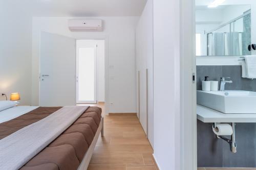 a bedroom with a large bed and a sink at Granatelli Holiday Home in Altavilla Milicia
